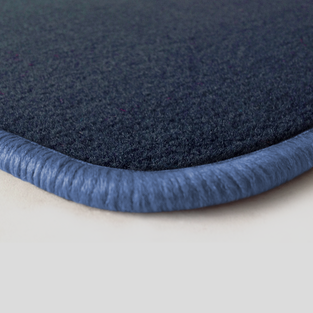 Eine Ecke als Beispiel einer Fussmatte Velours dunkelblau mit Rand in flieder.