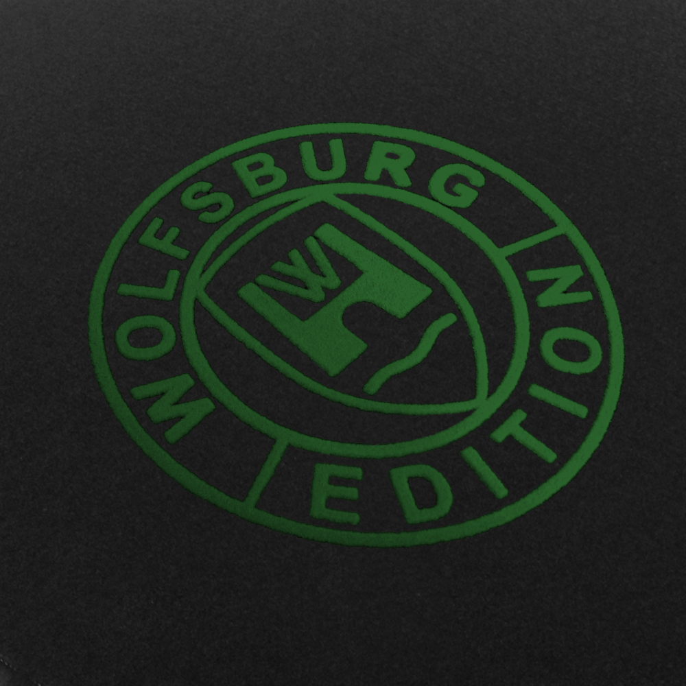 Das Wolfsburg Editions Logo auf einem schwarzen Teppich und das Logo ist in dunkelgruen.