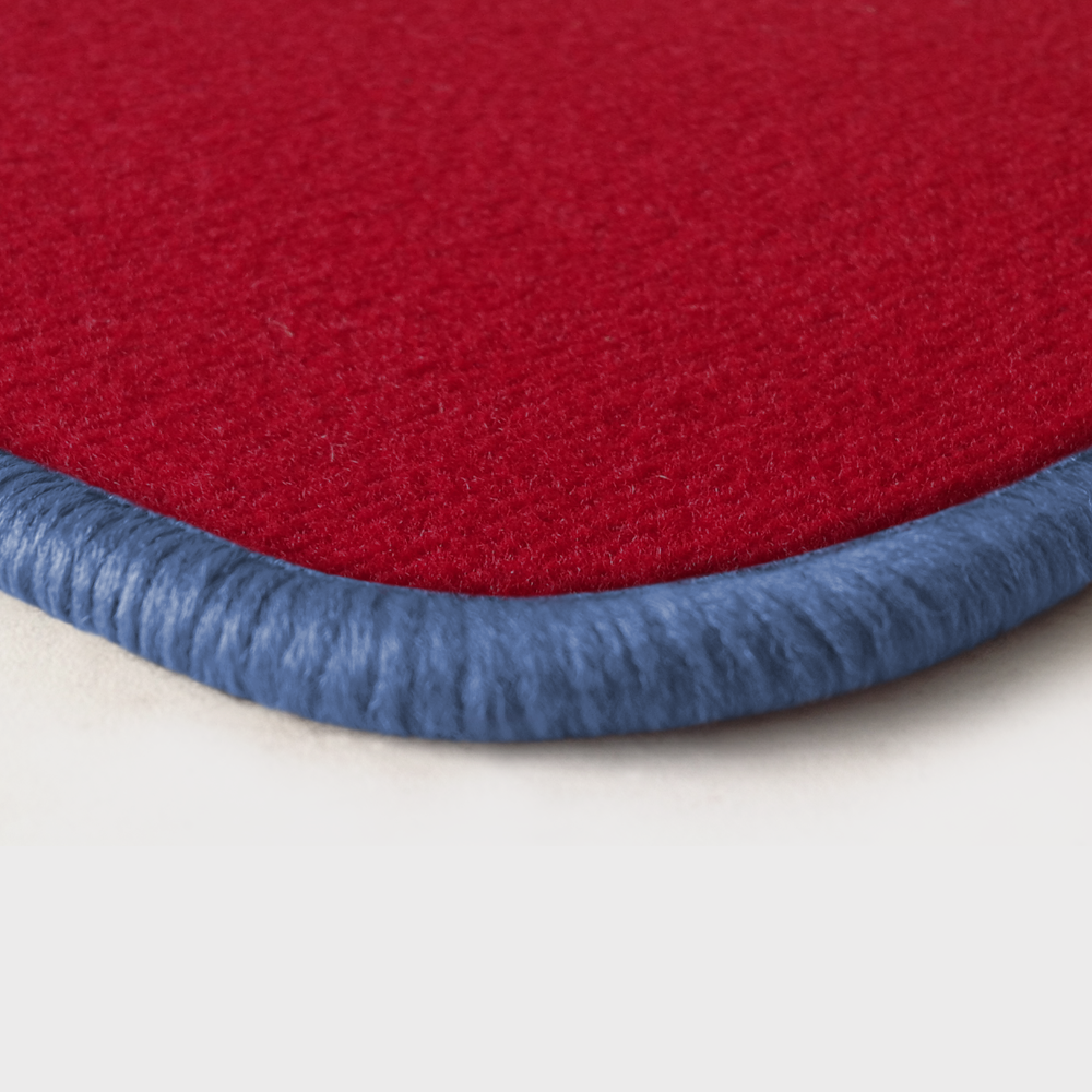 Eine Ecke als Beispiel einer Fussmatte Velours rot mit Rand in flieder.