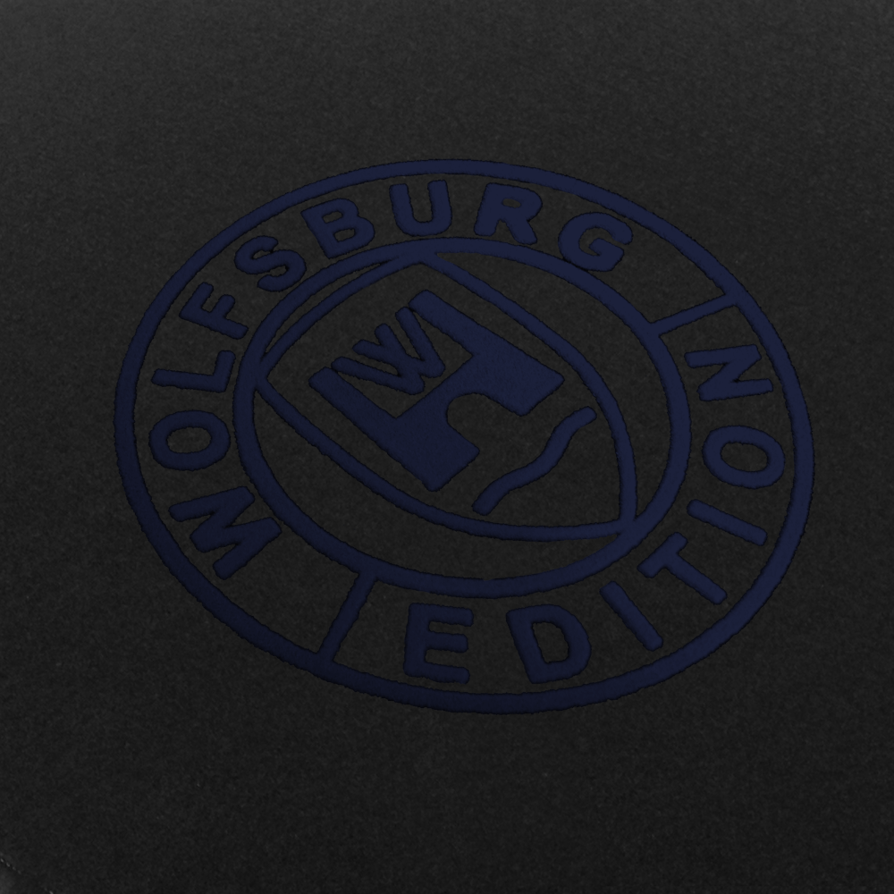 Das Wolfsburg Editions Logo auf einem schwarzen Teppich und das Logo ist in dunkelblau.
