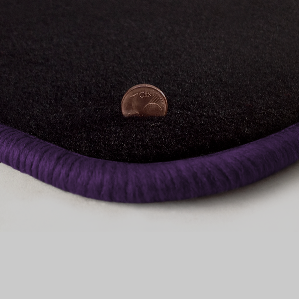 Eine Ecke als Beispiel einer Fussmatte Velours schwarz mit Rand in violett.