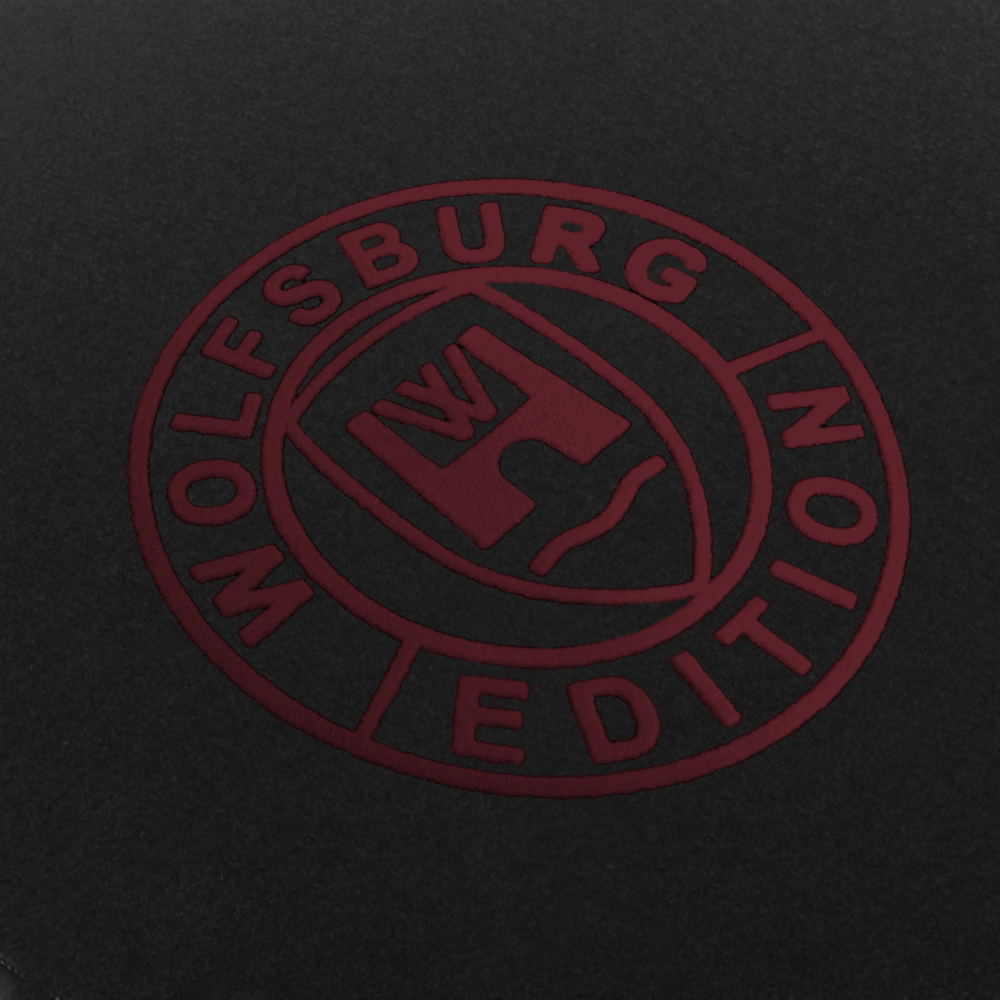 Das Wolfsburg Editions Logo auf einem schwarzen Teppich und das Logo ist in bordeaux.