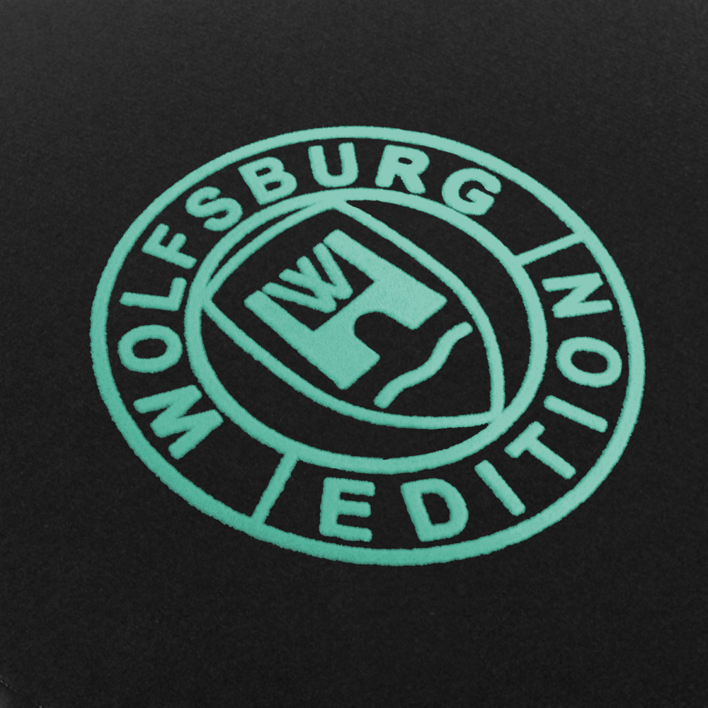 Das Wolfsburg Editions Logo auf einem schwarzen Teppich und das Logo ist in mint.