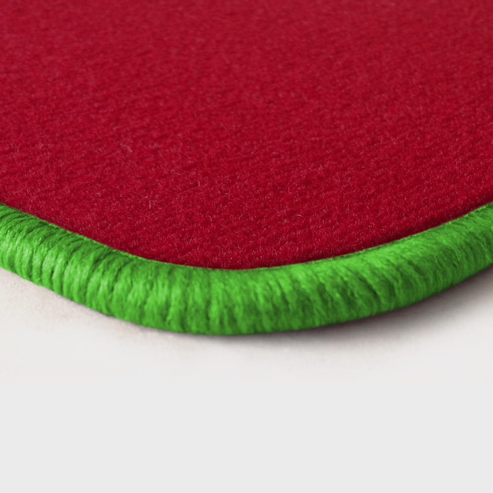 Eine Ecke als Beispiel einer Fussmatte Velours rot mit Rand in kawagruen.