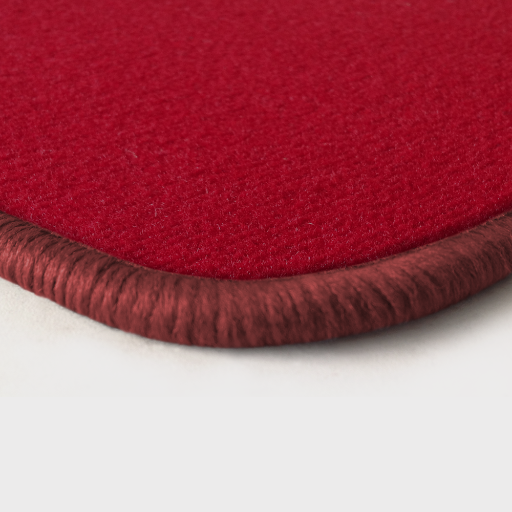Eine Ecke als Beispiel einer Fussmatte Velours rot mit Rand in rose.