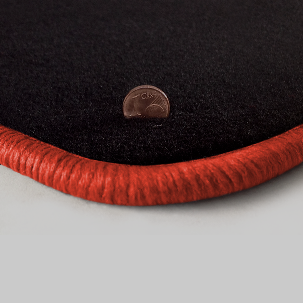 Eine Ecke als Beispiel einer Fussmatte Velours schwarz mit Rand in orange.